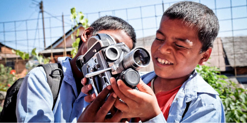 Two children holidng a camera.